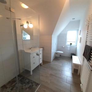 a bathroom with a shower and a sink and a toilet at Ferienwohnung Country in Born