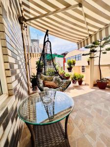 eine Terrasse mit einem Glastisch und einer Schaukel in der Unterkunft Bodhi Boutique Hotel in Kathmandu