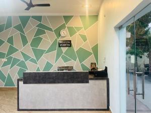 a lobby with a reception desk with a geometric wall at The Deerfield Cottages in Rāmnagar