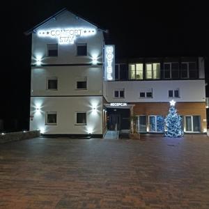 a christmas tree in front of a building at Comfort Stay, EV, Parking in Bolesławiec
