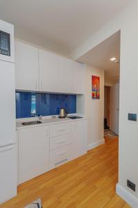 uma cozinha vazia com armários brancos e paredes azuis em Orbi City Luxury Towers em Batumi