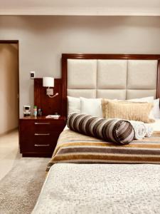 a bedroom with a large bed with a large headboard at Hotel Destiny in Ongwediva +55 photos