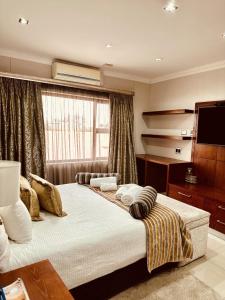Schlafzimmer mit einem Bett und einem Flachbild-TV in der Unterkunft Hotel Destiny in Ongwediva