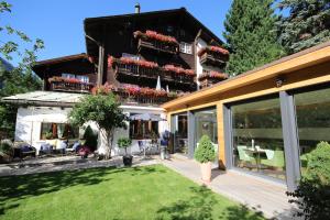 a house with a patio and a yard at Hotel Welschen in Zermatt