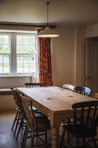 a dining room table with chairs and a light fixture at Coulin Farmhouse in Kinlochewe