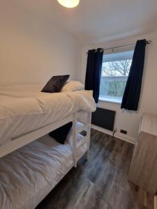 a bedroom with a bunk bed and a window at Over Torrs Cottage in New Mills