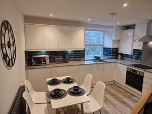 a kitchen with a table and chairs in a kitchen at Over Torrs Cottage in New Mills