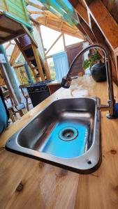 a kitchen sink with a faucet on a wooden counter at Ecocasa del Encuentro: única y confortable in La Calera