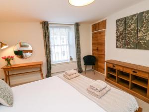 1 dormitorio con cama blanca y espejo en Pilchard Cottage en Dawlish
