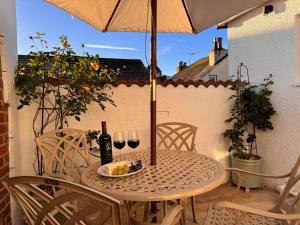 a table with a plate of food and two glasses of wine at Pilchard Cottage in Dawlish