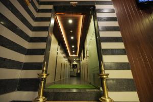 a hallway with black and white striped walls and stairs at Hotel Triton - Near US Embassy in Mumbai