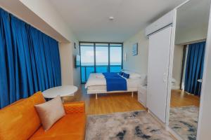 a bedroom with a bed and a couch at ORBI CITY SUITE in Batumi