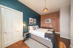 a bedroom with a bed and a brick wall at Central Apartment - Industrial in Blairgowrie