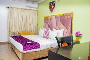 a bedroom with a large bed with a desk at Suru Express Hotel in Suru Lere