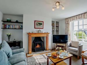 a living room with a fireplace and a tv at 4 Bed in Bude CRESC in Bude