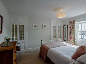 a bedroom with a bed and a desk and a window at 4 Bed in Bude CRESC in Bude
