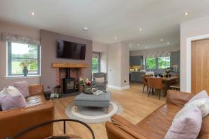 a living room with a couch and a fireplace at Slatehouse Cottage, Drumlanrig in Thornhill