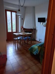 ein Esszimmer mit einem Tisch, Stühlen und einem TV in der Unterkunft residence La Bolognina 2 in Lizzano in Belvedere