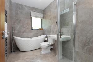 ein Badezimmer mit Badewanne, Toilette und Waschbecken in der Unterkunft Slatehouse Cottage, Drumlanrig in Thornhill + 18 Fotos
