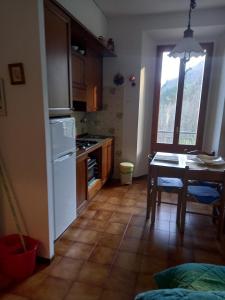 eine Küche mit einem Tisch und einem weißen Kühlschrank in der Unterkunft residence La Bolognina 2 in Lizzano in Belvedere