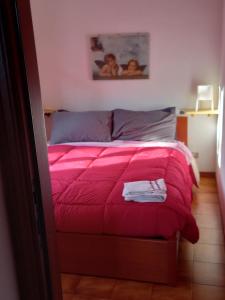 - un lit avec une couette rose dans une chambre dans l'établissement residence La Bolognina 2, à Lizzano in Belvedere