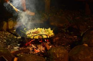 a pan with food on top of a fire at Margay - Reserva Natural y Lodge de Selva in El Soberbio