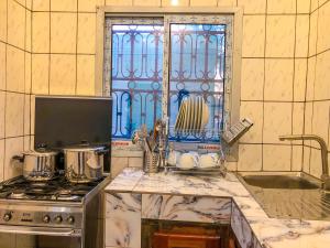 cocina con fregadero, fogones y ventana en Chic Appart au cœur de Douala Bonamoussadi, en Douala