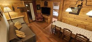 ein Wohnzimmer mit einem Sofa und einem Tisch in einer Hütte in der Unterkunft COURMAYEUR, VERRAND: IMMERSA NEL VERDE E CON VISTA in Verrand