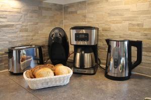 a counter with two coffee makers and a basket of bread at Ferienwohnung Abendsonne in Born