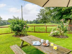 a wooden picnic table with a plate of food on it at 1 Bed in Yeovil HYDEC in West Coker