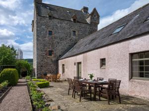 een patio met een tafel en stoelen voor een gebouw bij 5 Bed in Selkirk TOWER in Selkirk