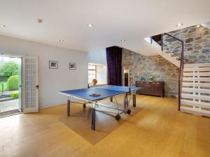 a ping pong table in a room with a stone wall at 5 Bed in Selkirk TOWER in Selkirk