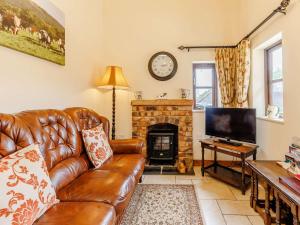 sala de estar con sofá de cuero y chimenea en 1 Bed in Telford 89144, en Leighton