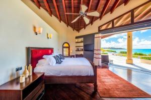 a bedroom with a bed and a view of the ocean at Casa la Playa in Baie Longue