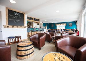 a bar with leather chairs and a chalkboard at Hanworth Country Park in Potter Hanworth