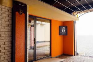 wejście do budynku z pomarańczowymi drzwiami w obiekcie Villa Boutique Hotel w mieście Mukaczewo