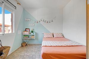 ein Schlafzimmer mit einem Bett mit einer orangefarbenen Tagesdecke in der Unterkunft Playa de Chilches in Chilches