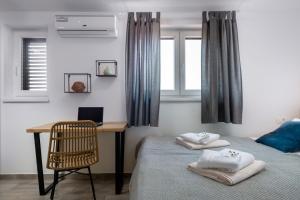 a bedroom with a desk and a bed with towels at Villa Kalista Istriana in Mednjan +42 photos