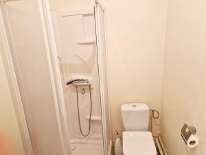 ein weißes Bad mit einem WC und einer Dusche in der Unterkunft Le Flambart YourHostHelper in Cherbourg en Cotentin