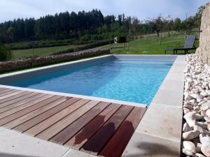 une grande piscine avec une terrasse en bois dans l'établissement Maison de 2 chambres avec jardin clos et wifi a La Vineuse, à La Vineuse