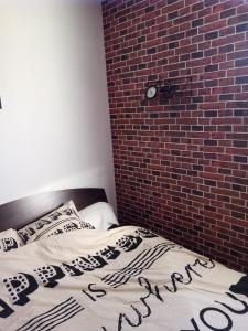 uma cama num quarto com uma parede de tijolos em Chambre dans appartement Saint Martin d'Hères près du Campus em Rhut