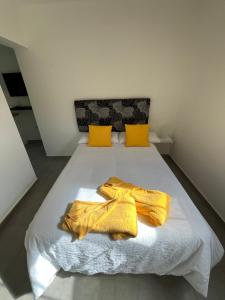 a bed with yellow blankets and yellow pillows on it at SUNNY CARMELITO DELUXE in Mogán