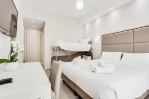Habitación blanca con 2 camas y silla en Hotel Cuba, en Milano Marittima