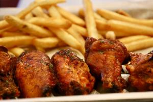 a plate of food with french fries and chicken wings at Sheraton Birmingham in Birmingham