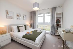 a white bedroom with a bed and a window at Poole Quay, elegant apt, sleeps 4, Wi-Fi & parking - Carters Quay View in Poole