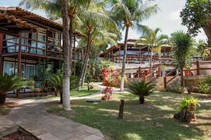 a resort with palm trees and a building at Pontal da Ferradura in Búzios