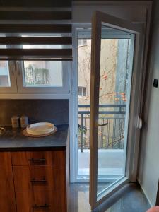 una cocina con una puerta corredera de cristal que da a un balcón en SALOMI LUXURY SUITES, en Ioannina 20 fotos más