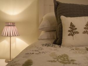 a bedroom with a bed with a pillow and a lamp at 2 Bed in Launceston 41992 in Saint Giles on the Heath