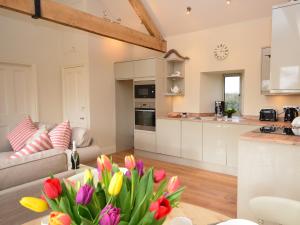 a kitchen and living room with a couch and a table with flowers at 2 Bed in Sherborne 41897 in Yetminster