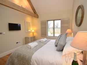 um quarto com uma grande cama branca e uma janela em 2 Bed in Sherborne 41897 em Yetminster